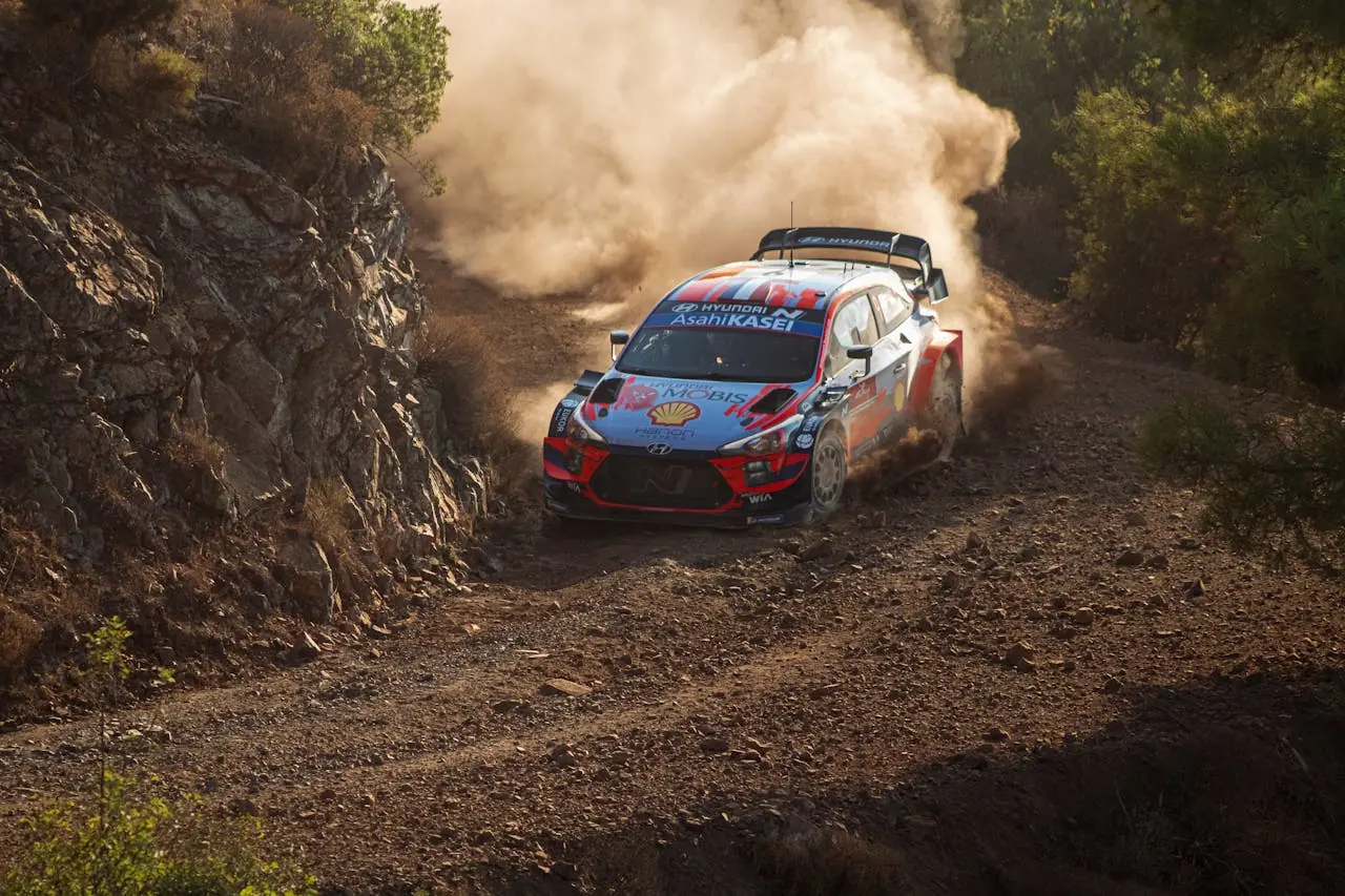 Exciting rally race car speeding on a dusty dirt road, showcasing dynamic motion and adventure.
